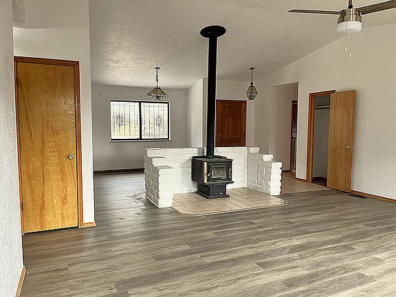 Wood Burning Stove with Dining nook behind and new floors and paint throughout.