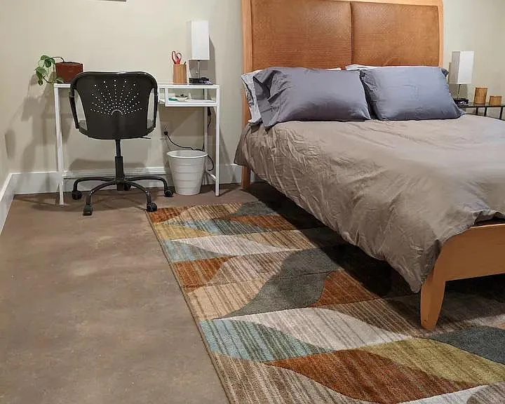 The main bedroom is spacious and can accommodate a bed as well as a desk.