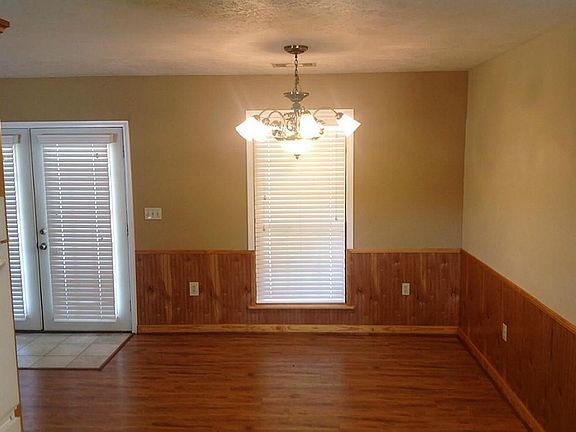 DINING ROOM HAS HARDWOOD FLOORING AND WAINSCOT PANELING