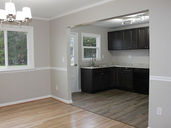 Open kitchen with sleek, dark, and modern cabinets.