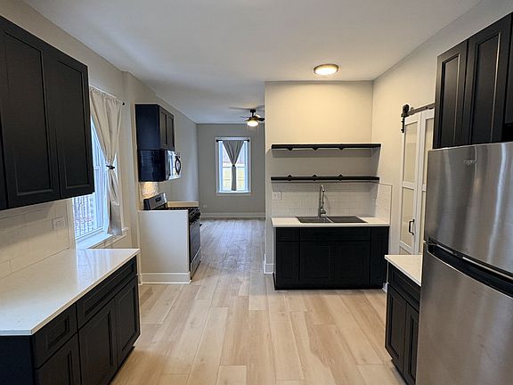 Spacious kitchen with ample storage, open shelving, and flexible layout for dining or living