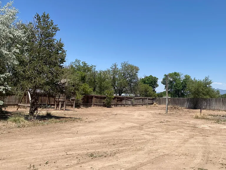 Large backyard enclosed with a wooded fence.