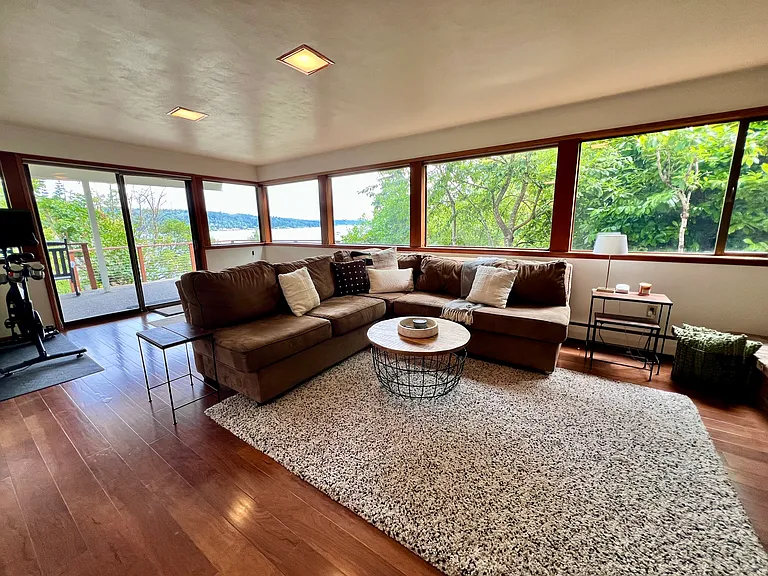 Lower-level basement with engineered wood floors, fireplace insert, and views of the lake.