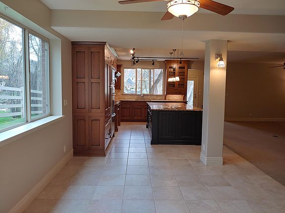 View of kitchen from dining area. Ceiling fan over dining area.
