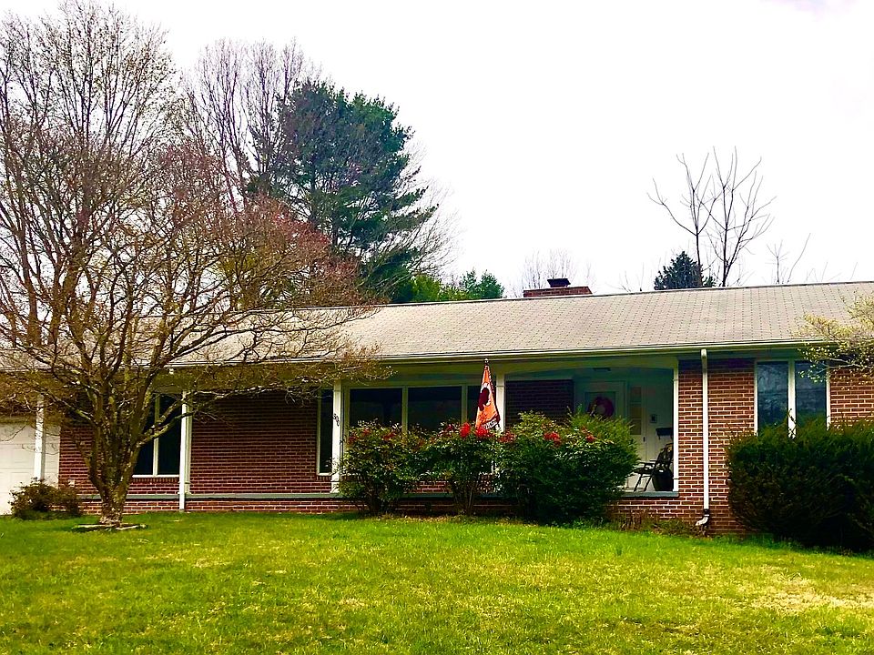 Large brick home with driveway that fits many cars.