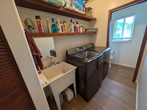 Washer, dryer and laundry tray at front of house.