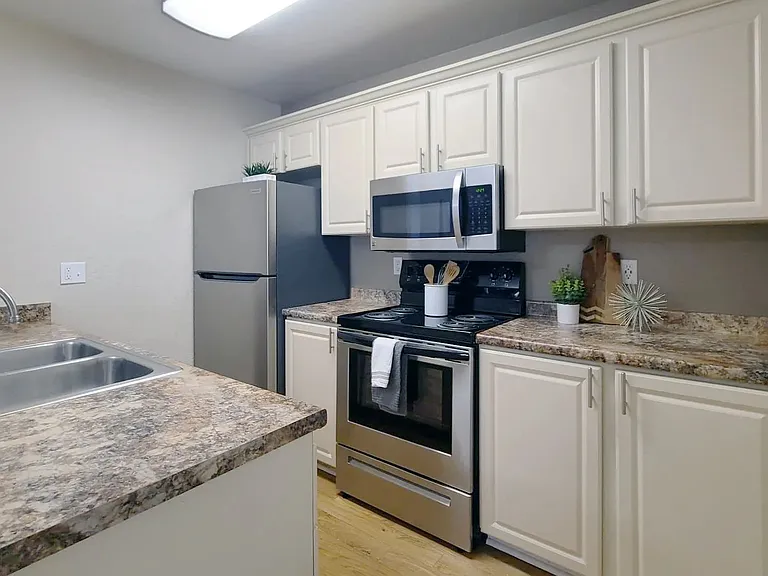 Kitchen magic with granite-style countertops, wood-style floors, and cabinets galore.