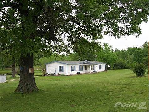 What a pretty setting this home sets off a paved road and features 20 acres. A very nice pond,some woods and some good pasture along with a very nice barn/shop area