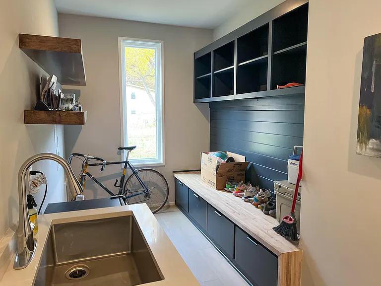 Ground floor mudroom with storage and laundry hook up that leads to garage