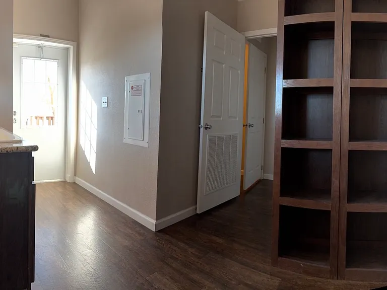 laundry room with sink on left, shelves on right, and door to side porch