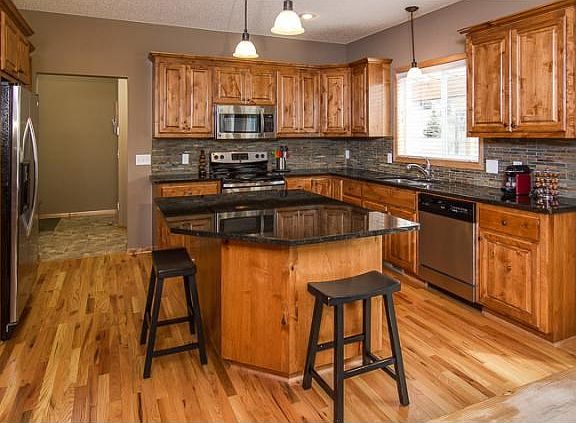 Kitchen sink window overlooking the backyard, large center island, stainless appliances, custom backsplash.