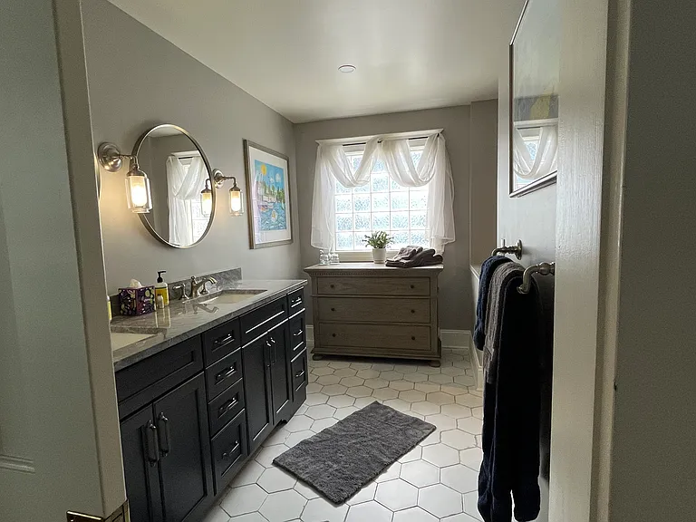 Recently remodeled primary bathroom has a bidet style toilet fixture.