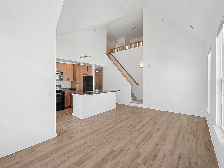 Bright open-concept living area featuring a modern kitchen with sleek appliances and a stylish loft space.