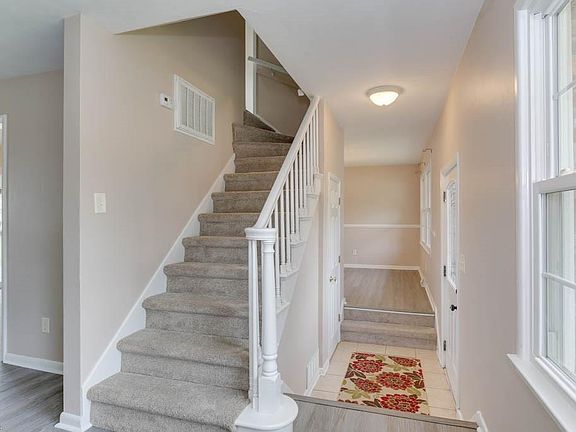 Front foyer with view of the dining room & stairs.  Door to the left is the coat closet