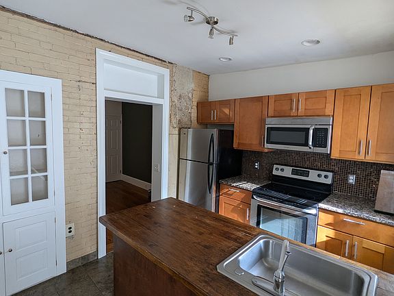 The kitchen island is large enough for guest stools. The brick wall was revealed during renovation.