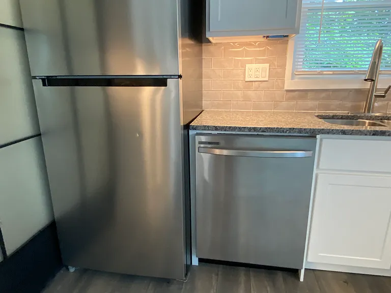 Energy-efficient refrigerator with automatic icemaker and dishwasher next to the laundry room
