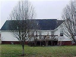 Rear of house immaculately landscaped with large deck!
