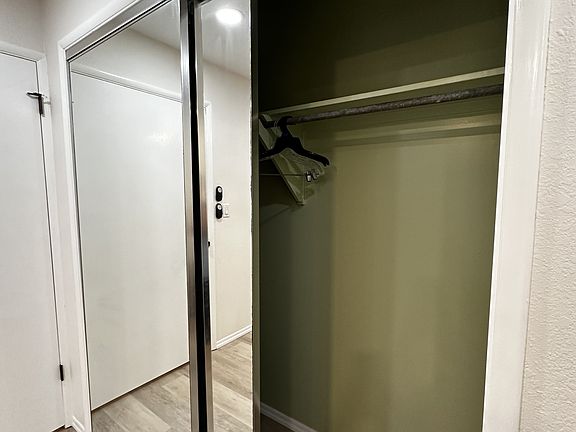 Generous sized closet with two full mirrored doors.