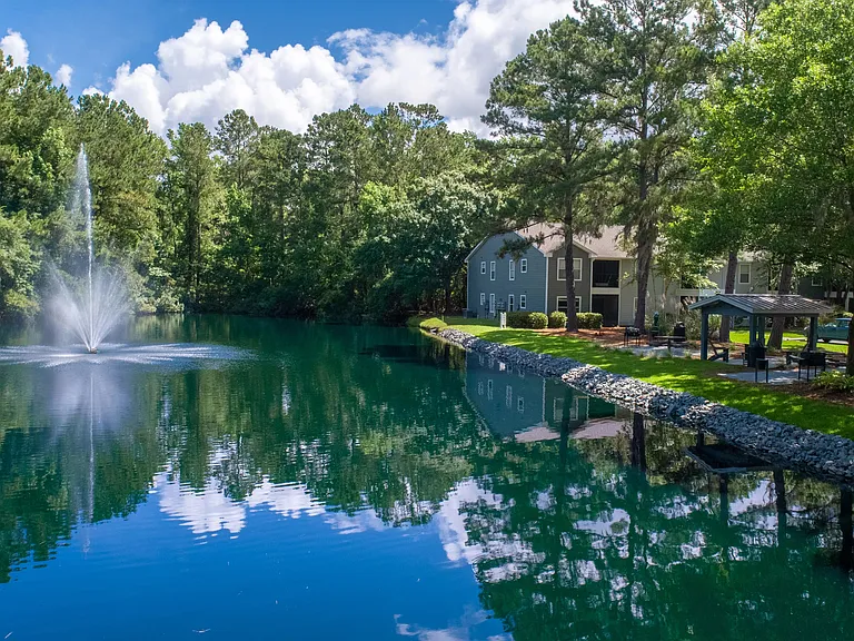 Serene waters, a central fountain, and lush green surroundings create a peaceful oasis right in the heart of the community.