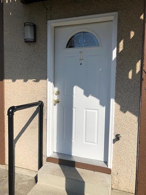 Front door with large fenced green space
