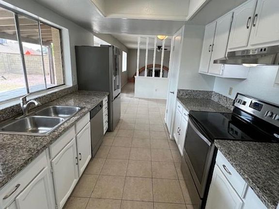 Kitchen with pantry, stainless appliances, and granite countertops.