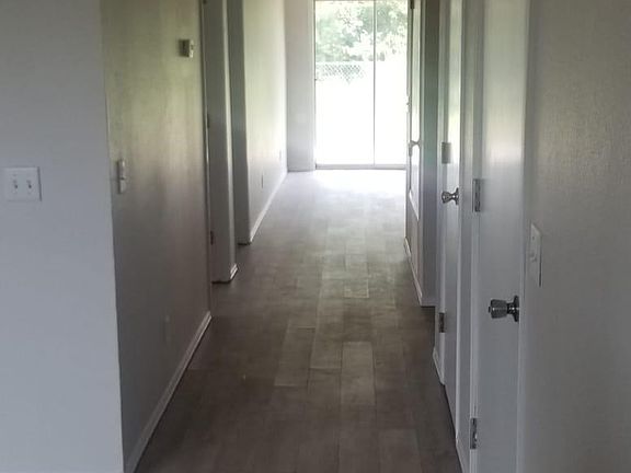 Standing at front door entry with hallway to back of unit.
