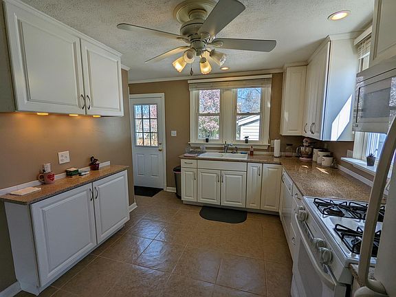 New kitchen with large, white, cushion-close cabinets. Large ceramic double sink. Oven with gas range.