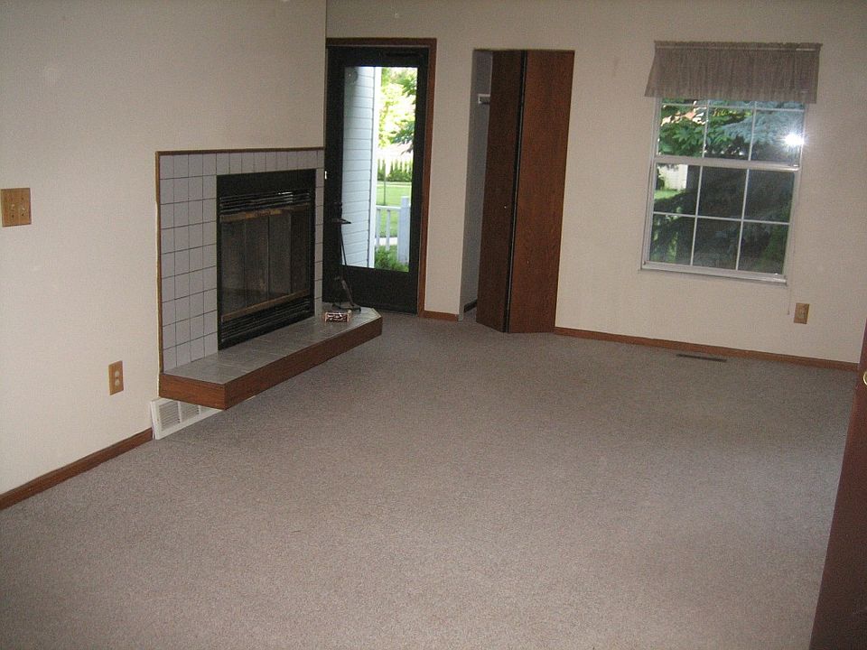 Front door into living area with closet and windows