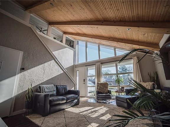 View of living room and upstairs loft bedroom.  Natural sunlight galore.