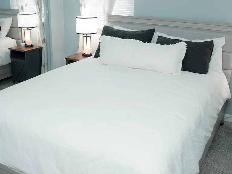 A serene space featuring soft blue tones, delicate floral art, and a plush, comfortable bed.