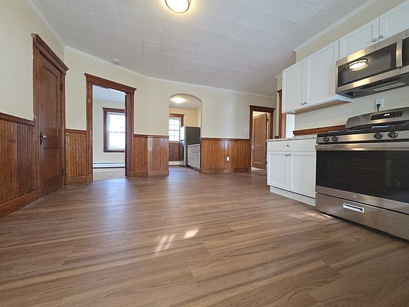 Large eat in kitchen large with new stove and new floor along with original hardwood trim and molding