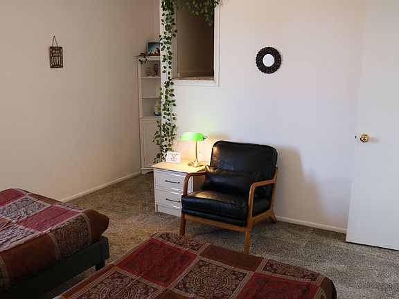 Second bedroom, another angle showing leather chair, cubby hole storage, closet.