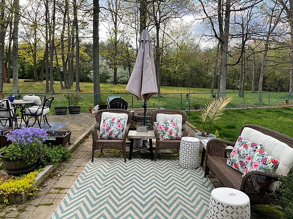 Back yard. Brick patio, with fire pit. Woods behind house.