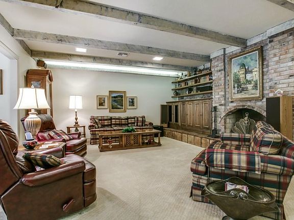 Family room with custom lighting, custom entertainment cabinet, and wood burning fire place.