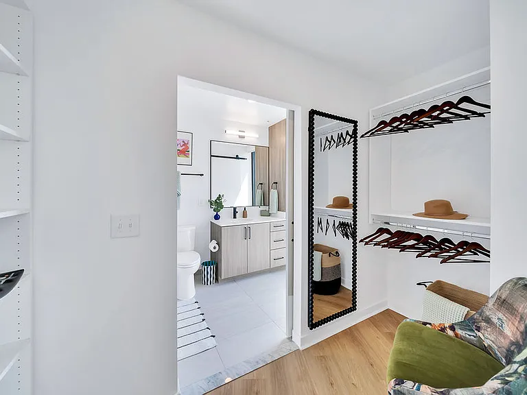 Oversized closet with built-in shelves and view into the bathroom.
