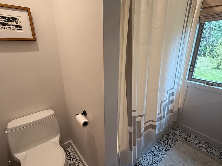 Downstairs newly renovated bathroom with tub and shower.