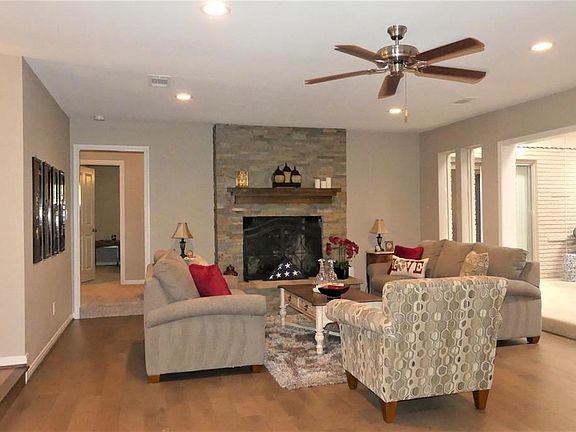 Beautiful gaslog fireplace with floortoceiling stone surround.