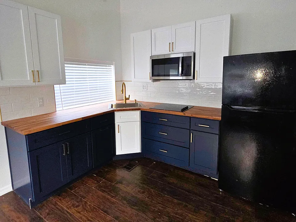 Spacious kitchen with ample cabinets, refrigerator, and microwave for your convenience.