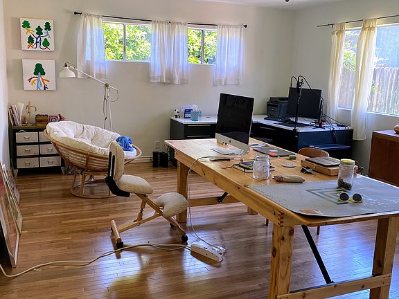 Master bedroom, here used as an office. It's very large, lots of windows, has its own bathroom and separate entrance from the backyard. Could be used for another person to live here!