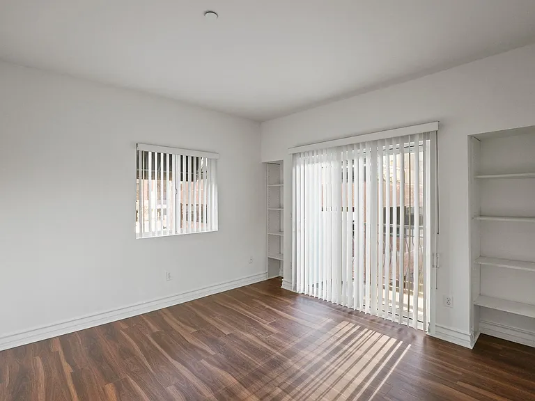 Bedroom with Built-In Shelving and Balcony