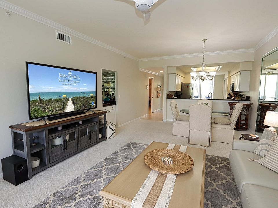 Spacious living area w/queen sleeper sofa, large TV, and small built-in bar ... This area can be expanded into the enclosed back lanai by opening the sliding stacker doors.