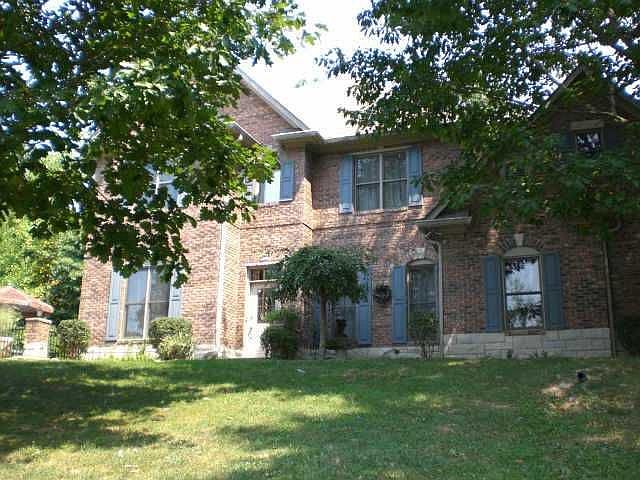 Front of home sits back off of road.