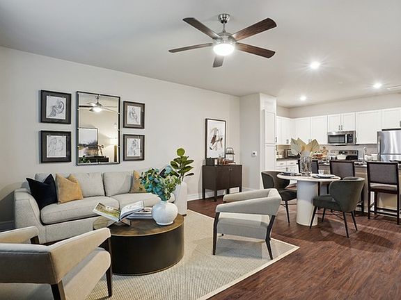 Spacious open floor plan style apartment with hardwood flooring and stainless steel appliances