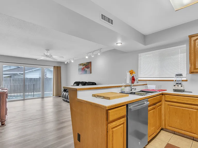 Kitchen and living room with 50-inch tv, couch and recliner. Door going towards the pool.