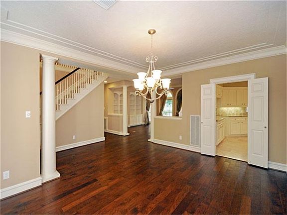 Another view of the dining room showing the stately columns and entrances into the formal living space and the kitchen.