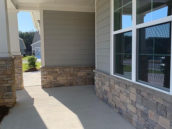 Spacious front porch for sitting area. Windows to Bedroom 1, which has privacy shades (installed mid-June.)