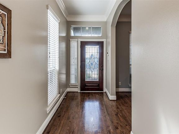 The light filled entry accented by hardwood flooring and floor to ceiling windows, located beside both formal rooms.