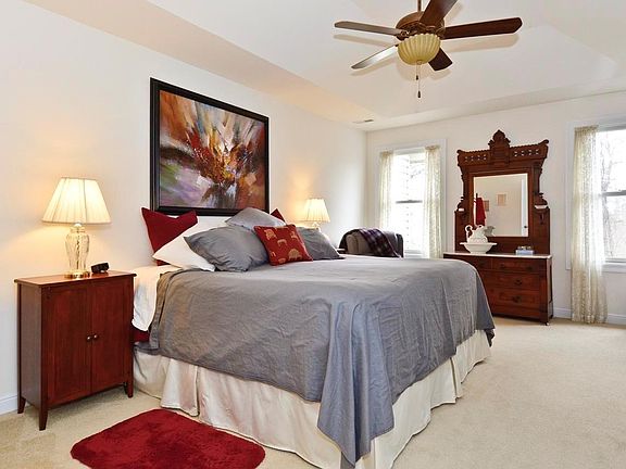Neutral Master bedroom with coffered ceiling and ceiling fan