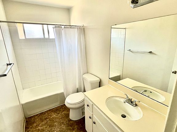 Large mirror , linoleum flooring , bathtub , bathroom heater