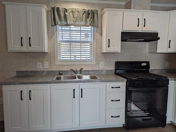 Sink with window and stove with exhaust to outside